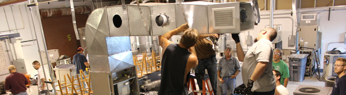 Students working on an air conditioning unit.