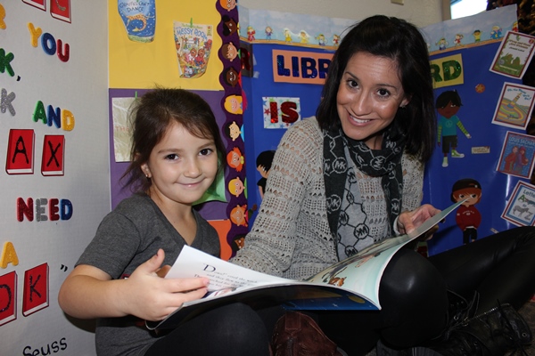 Student reading to a young child.